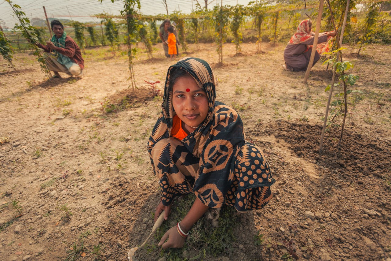 Woman engaged in farming activities in a rural Bangladeshi community garden.